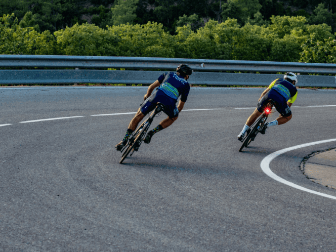 two cyclists descending a switchback on smooth pavement