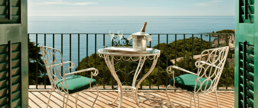 A bottle of champagne on a table on the balcony of a room at the hotel La Gavina