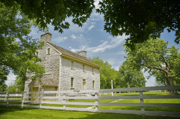 White fence and white stonewashed building at the Shaker Village of Pleasant Hill