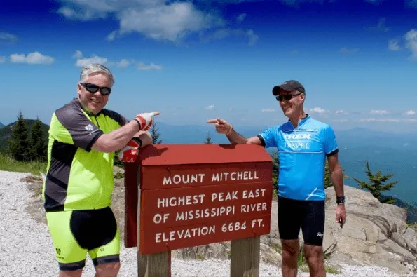 Two cyclists all smiles at Mt Mitchell Summit