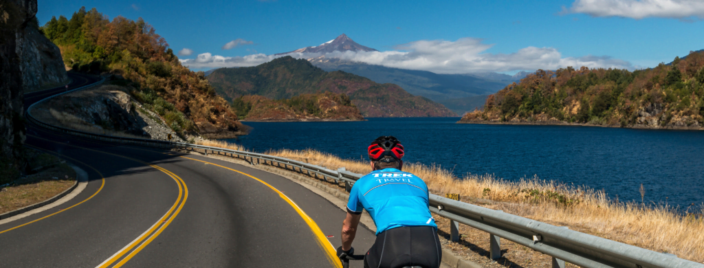 A cyclist along the lake riding towards a mountain in Chile