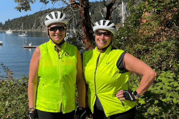 two people smiling with their bike helmets on