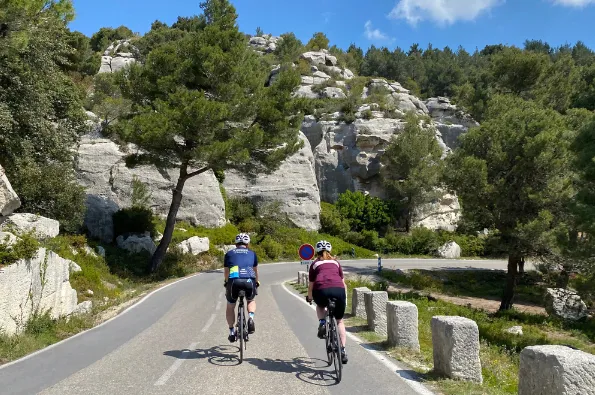 A couple of riders from the back in a rocky environment