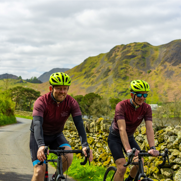 two people cycling in England with matching jerseys and helmets