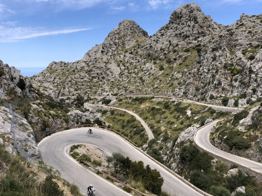Landscape view of cyclists on Sa Calobra, with road twisting through the mountains