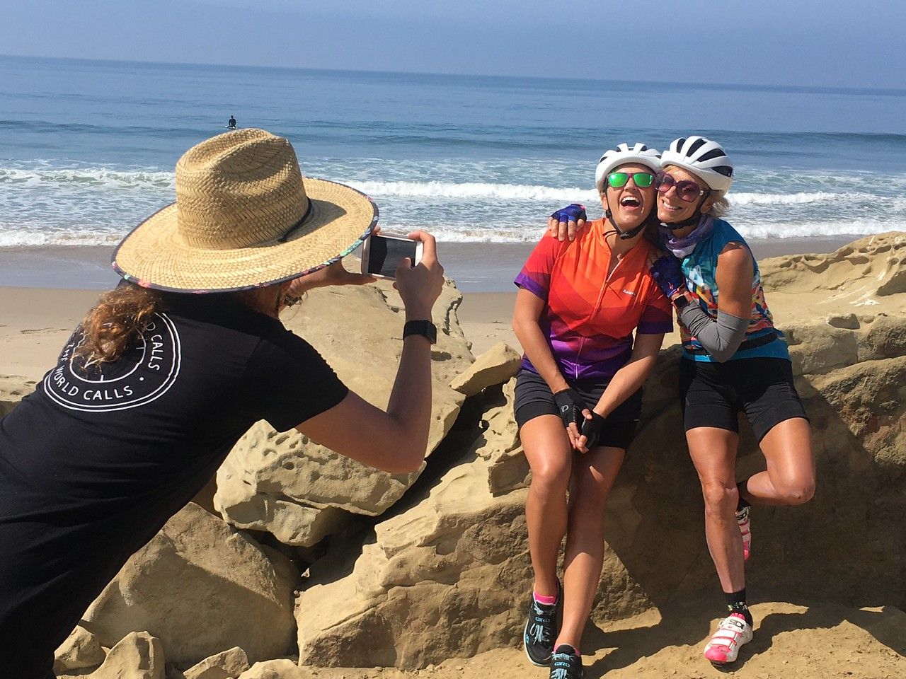 two female friends smiling as their Trek Travel guide takes their picture with the beach in the background