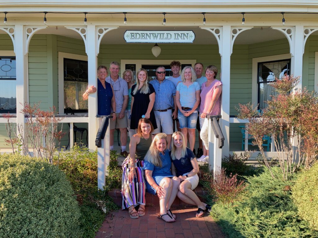A group of people pose on the front porch of the Edenwild Inn