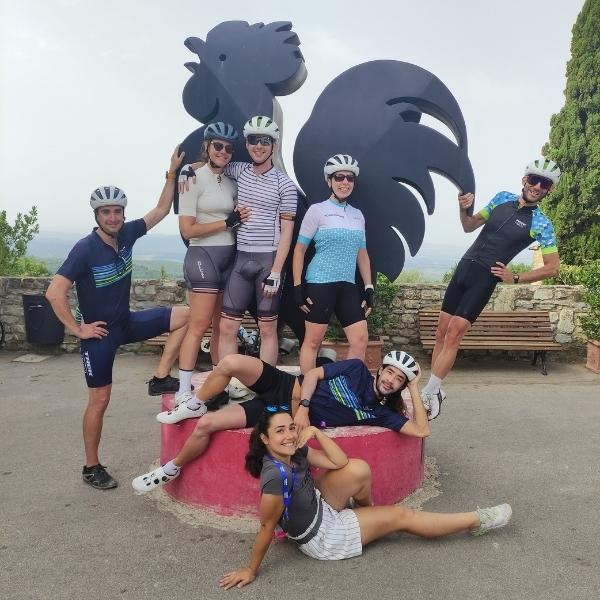 A group pose around the black rooster symbol of Chianti in Tuscany