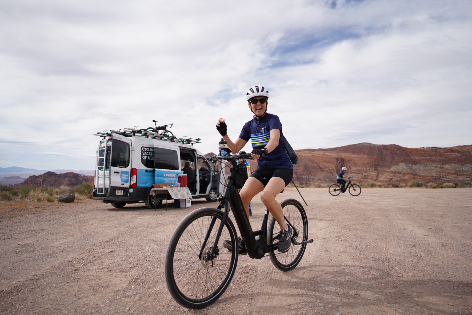 A woman on a Verve+ ebike with the Trek Travel van in the background.