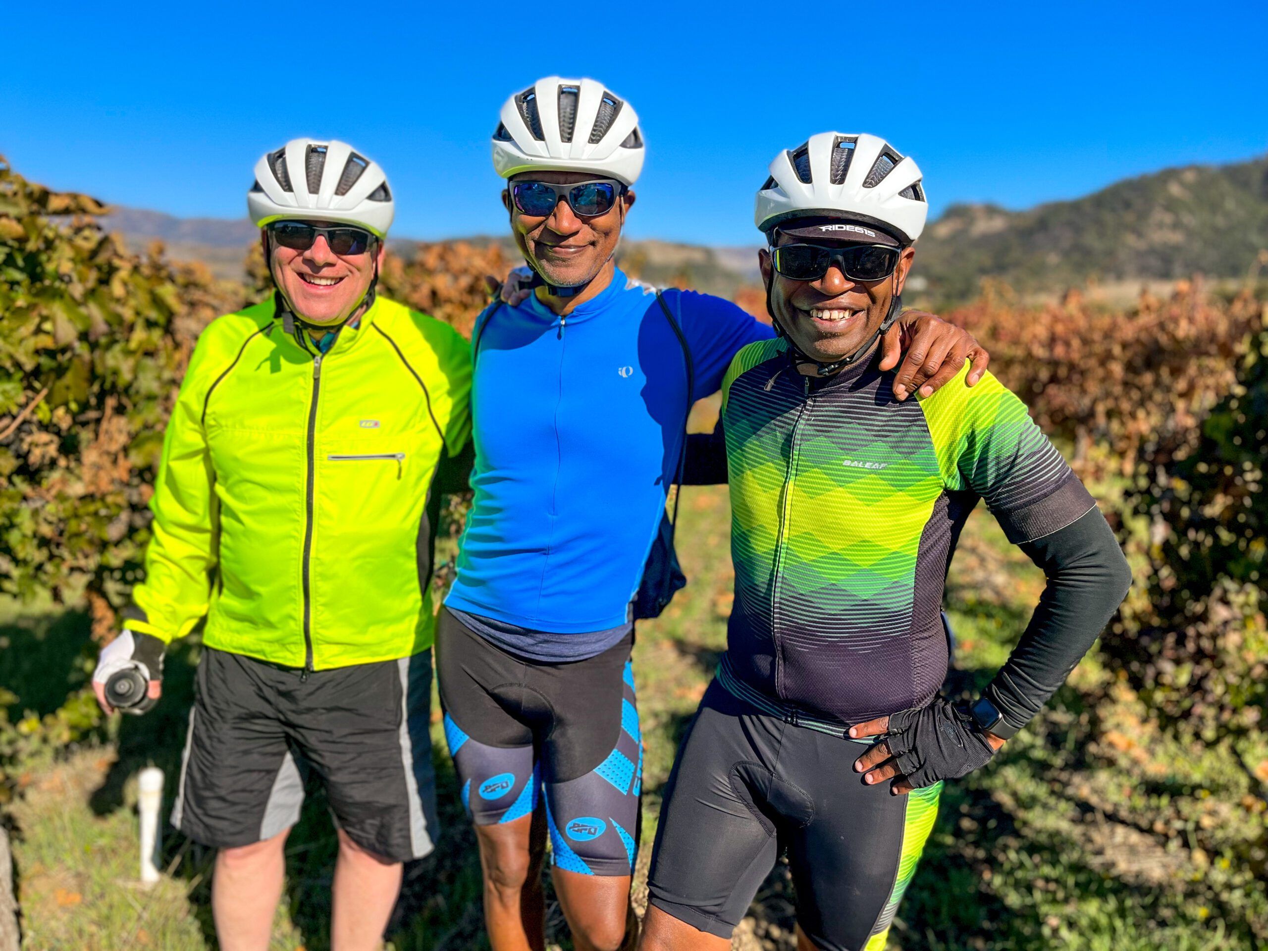 three people posing with their bike helmets on