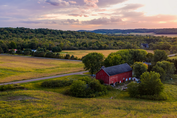 Arial image of the farmland, a red barn and dusk skies outside of Madison, Wisconsin