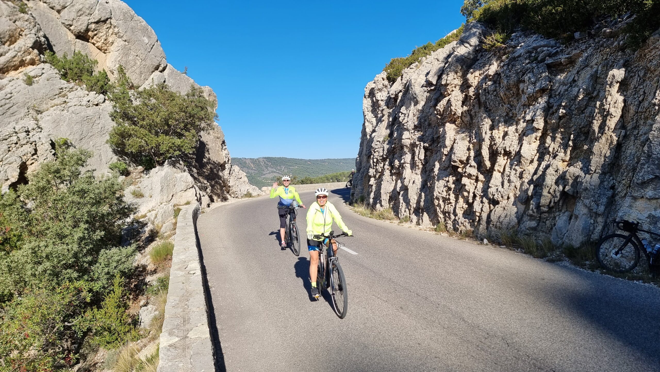 A couple of cyclists waving at the camera in Gorges du Verdon