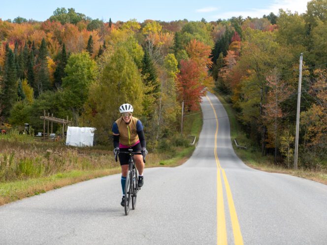 Cyclist riding towards camera along road in Vermont