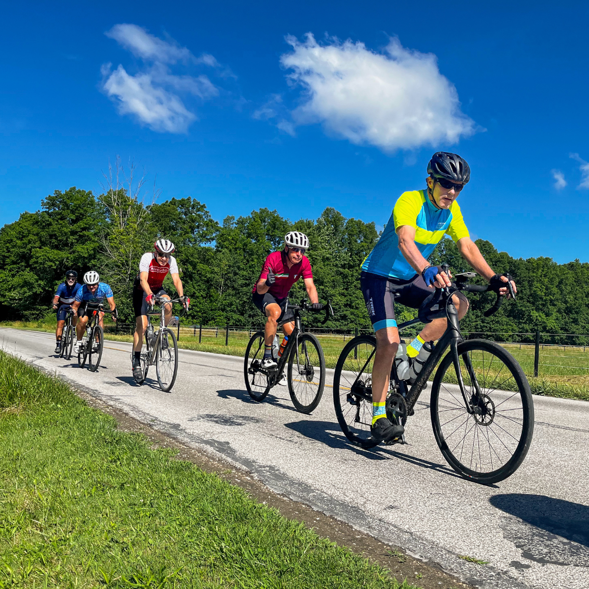 A group of cyclists riding on an open r