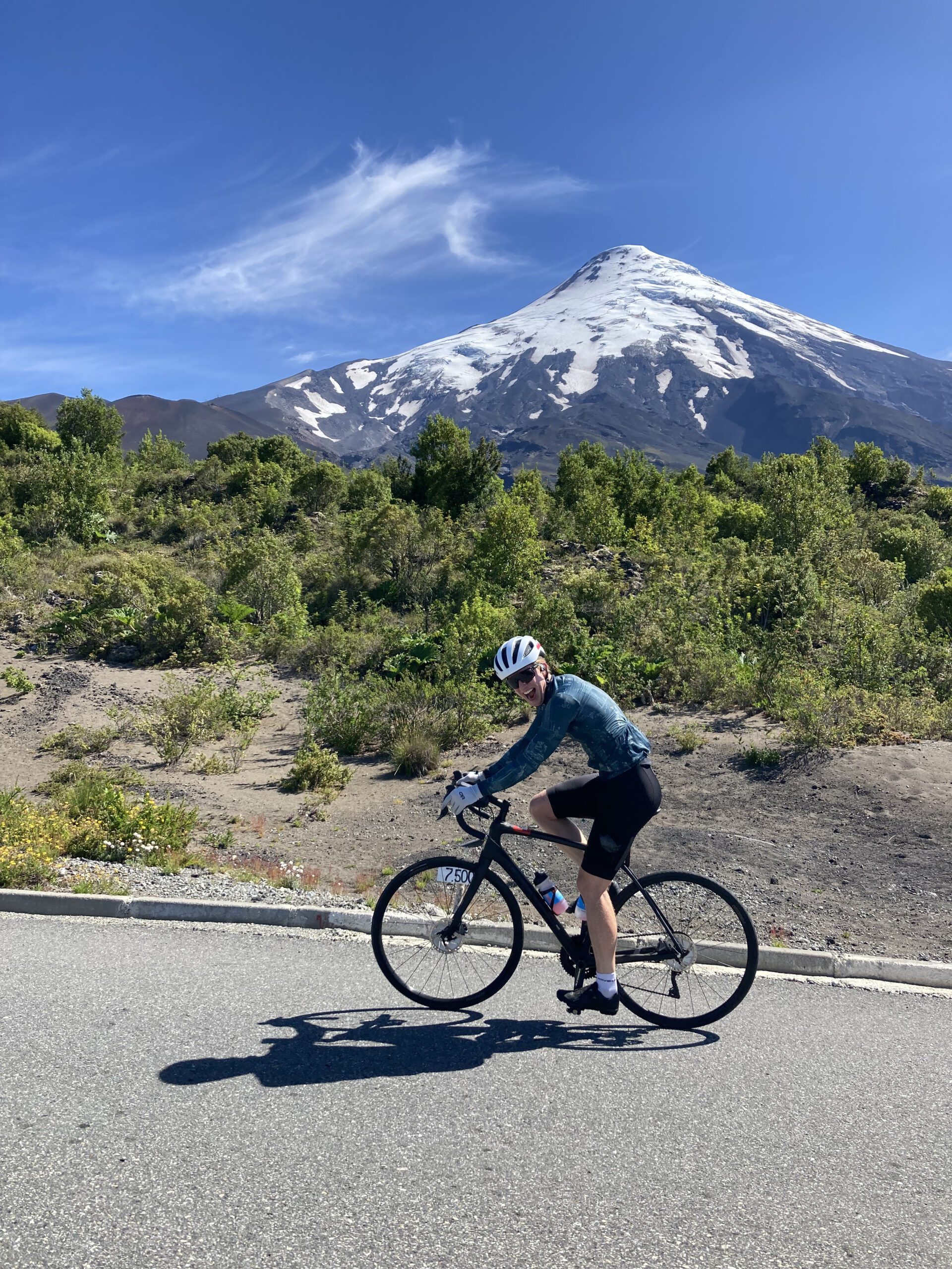 Cyclist in Chile with snow-covered volcano in the background