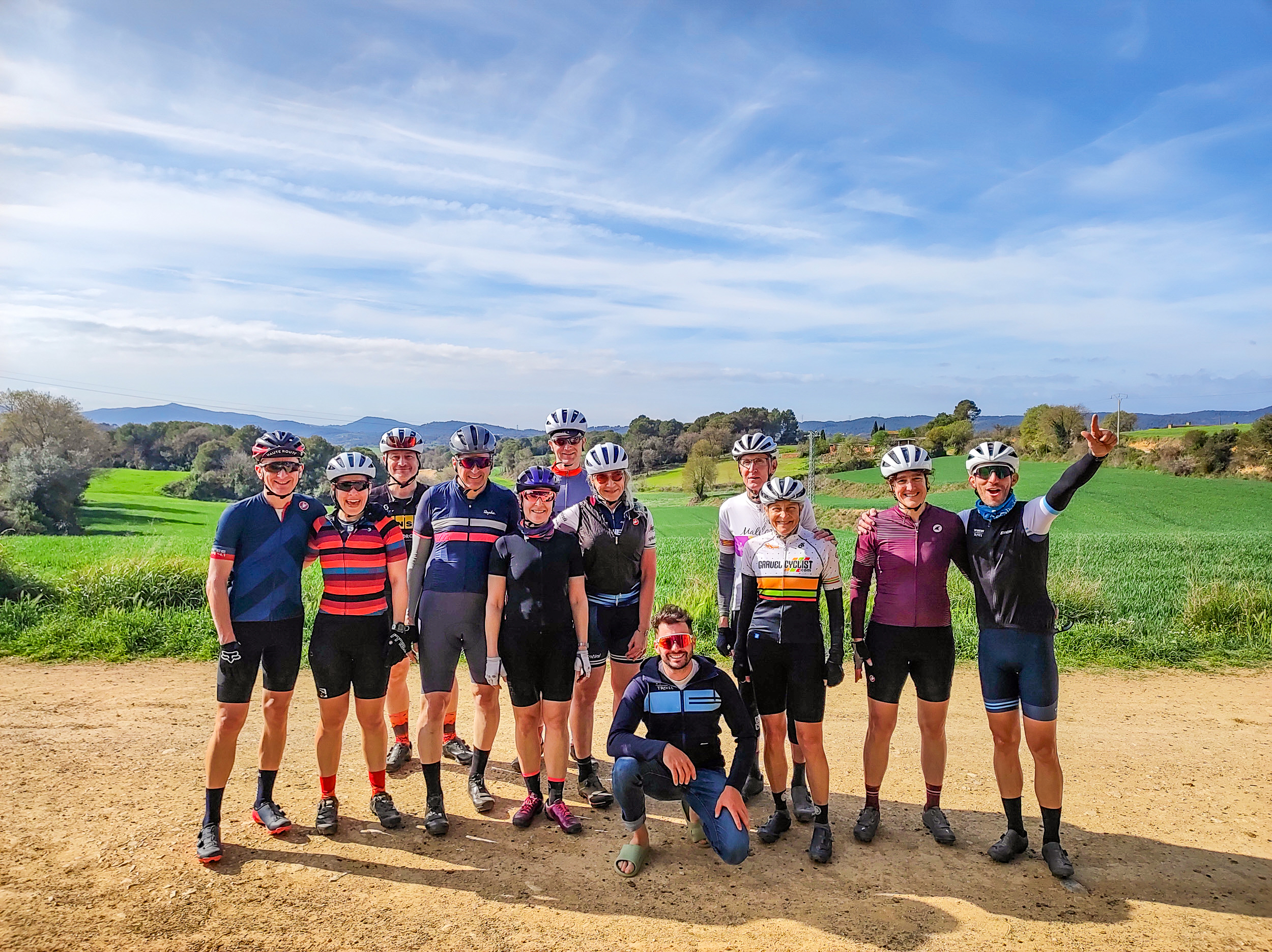 A group of gravel cyclists pose in front of a rolling landscape