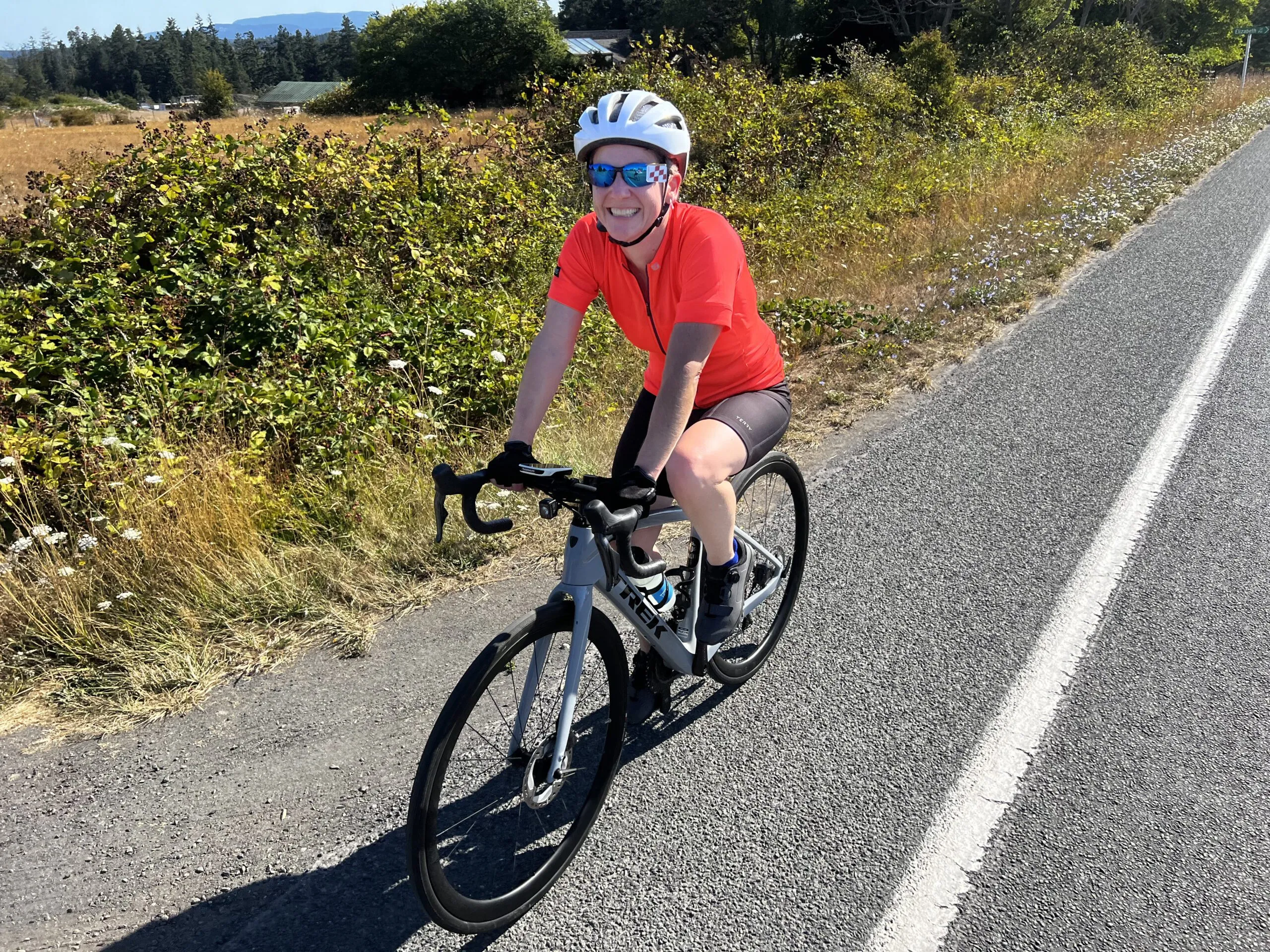 Cyclist smiling while riding on a country road