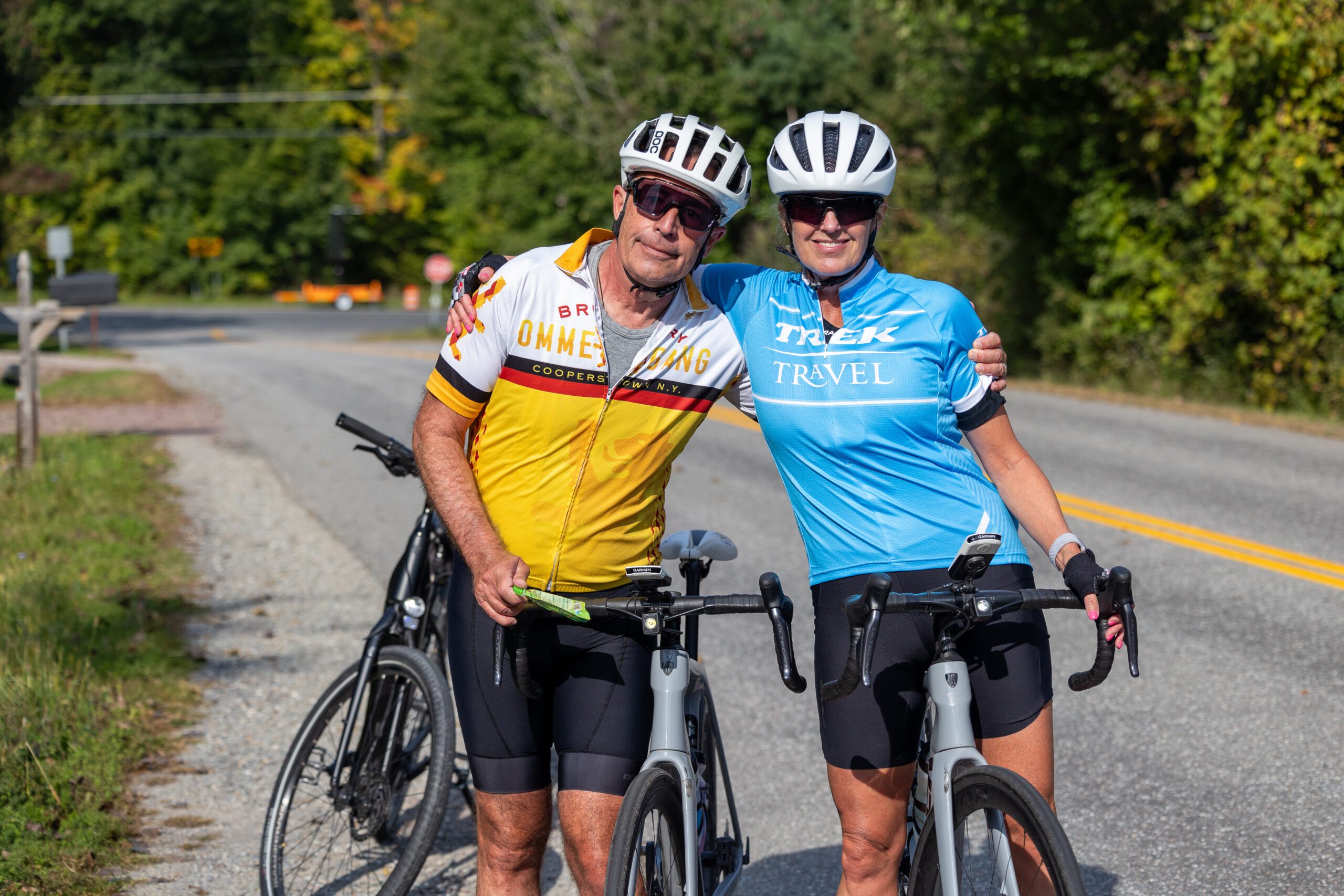 Two cyclists with arms around each other, smile for the camera