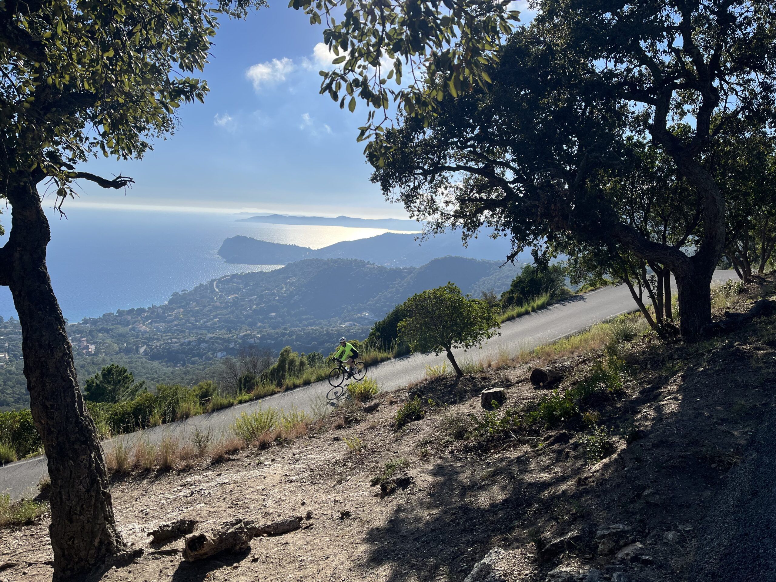 A person riding on the Route des Crêtes in the French Riviera, with the sea in the background