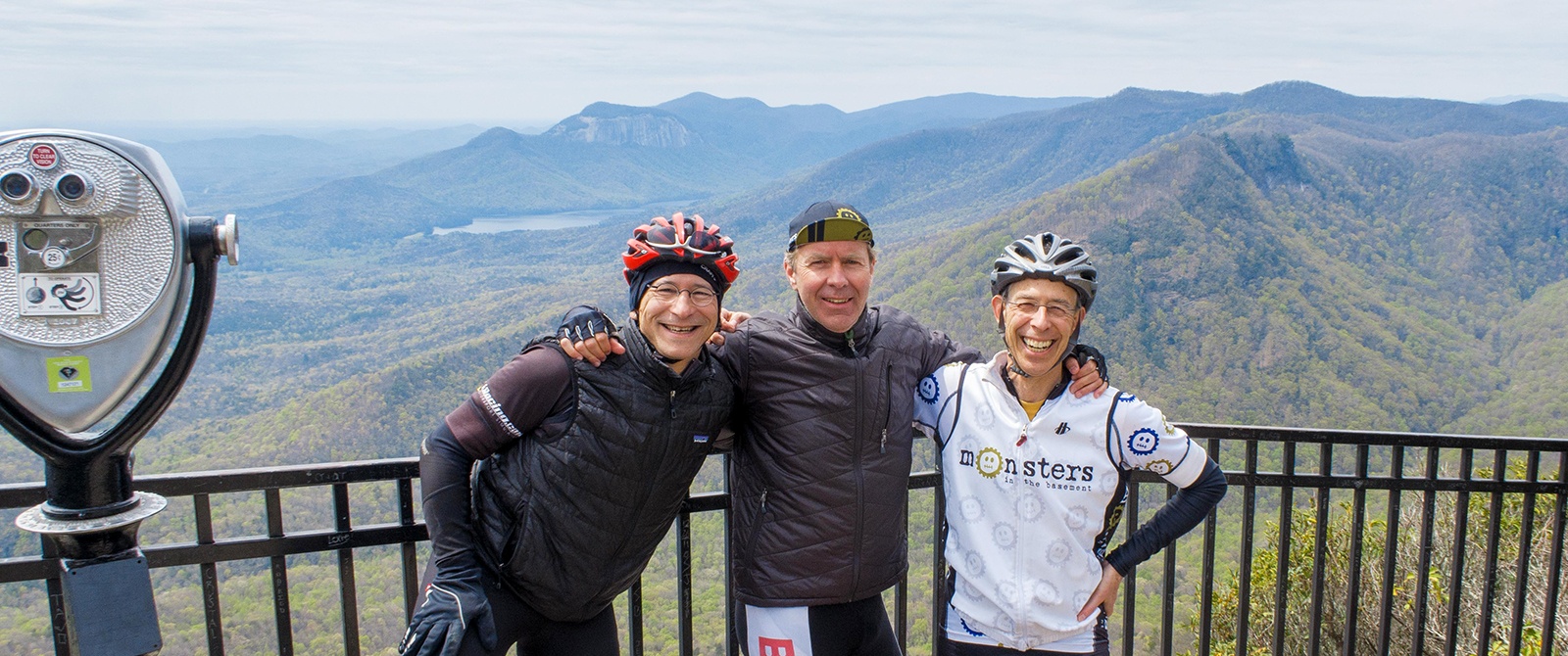 three smiling cyclists at the top of Ceasars Head viewpoint