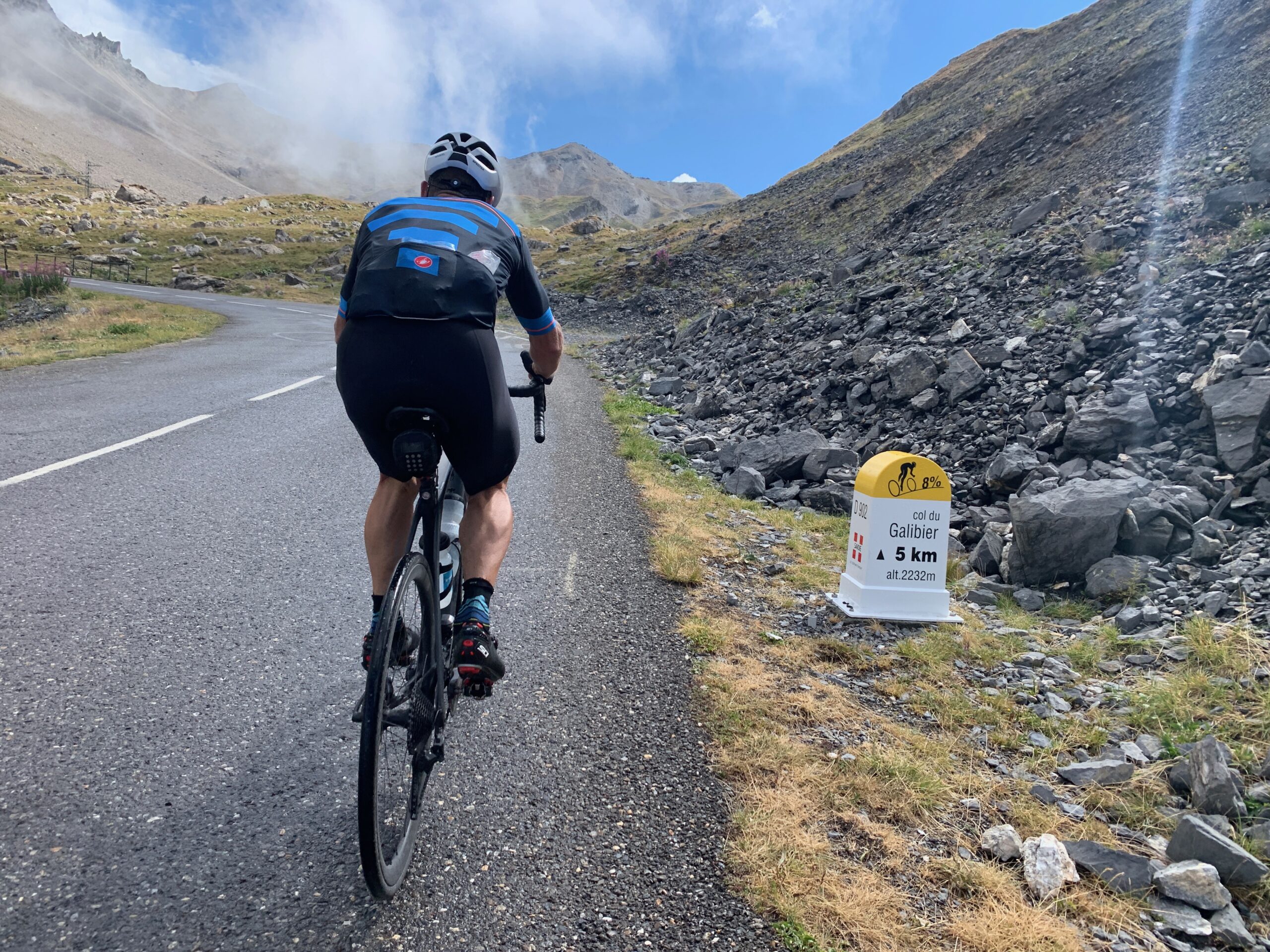 A rider next to a Col du Galibier milestone