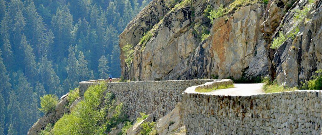 a person cycling on a winding road