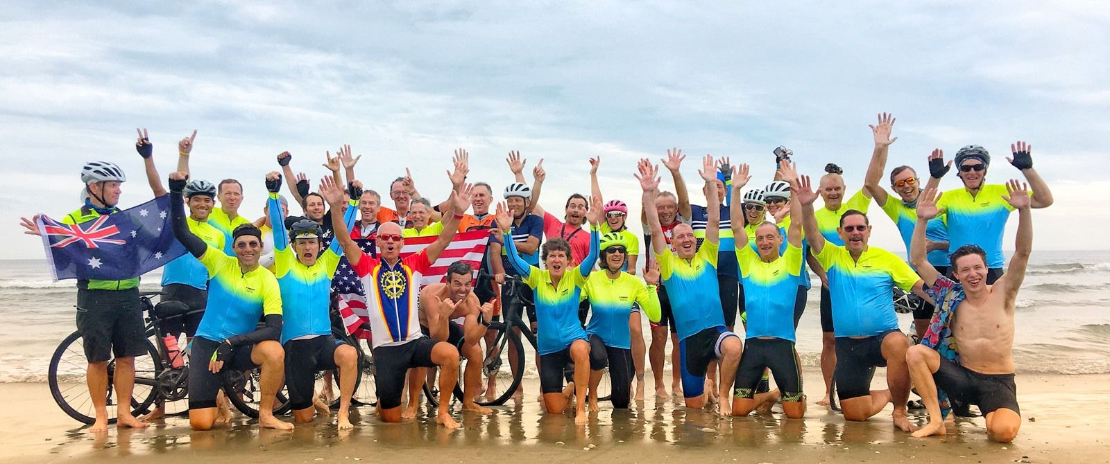 Group of people standing on the beach celebrating