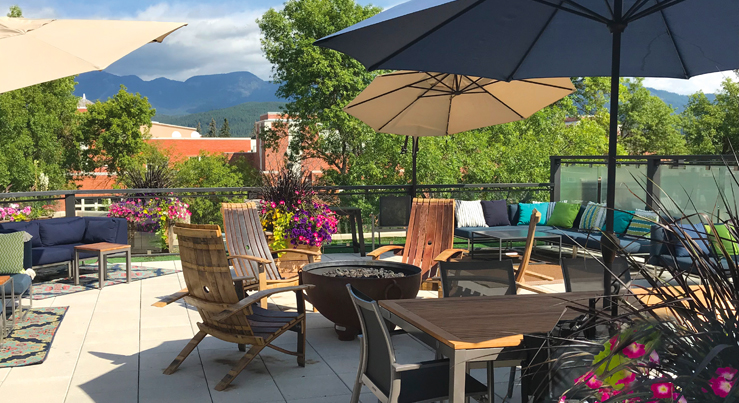 The Firebrand Lodge outdoor patio with seating, firepit and umbrellas