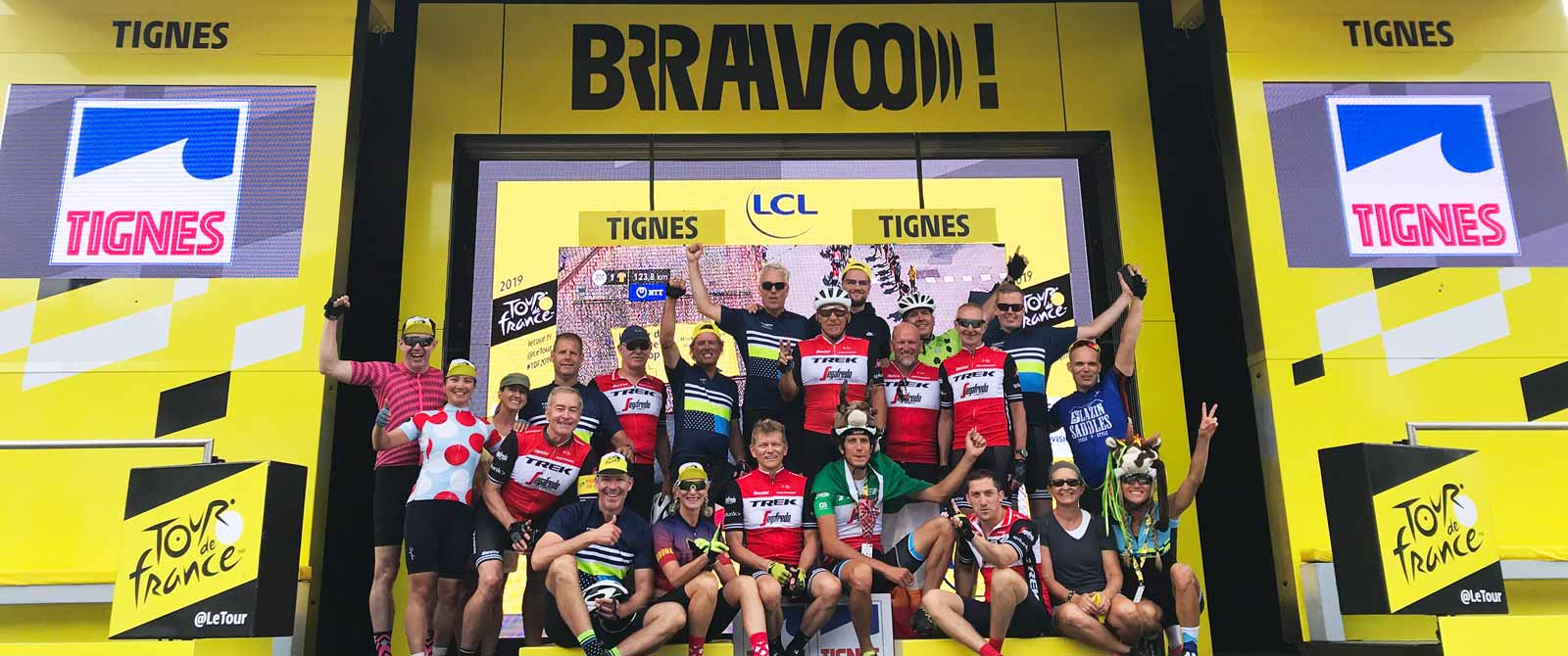 A group of people in cycling gear posing on the podium on TDF