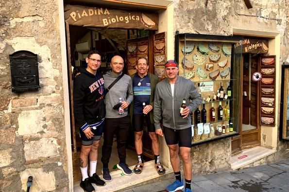 Four people smile for a photo in the doorway of an Italian cafe