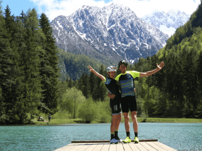 Two people in front of a lake and mountain