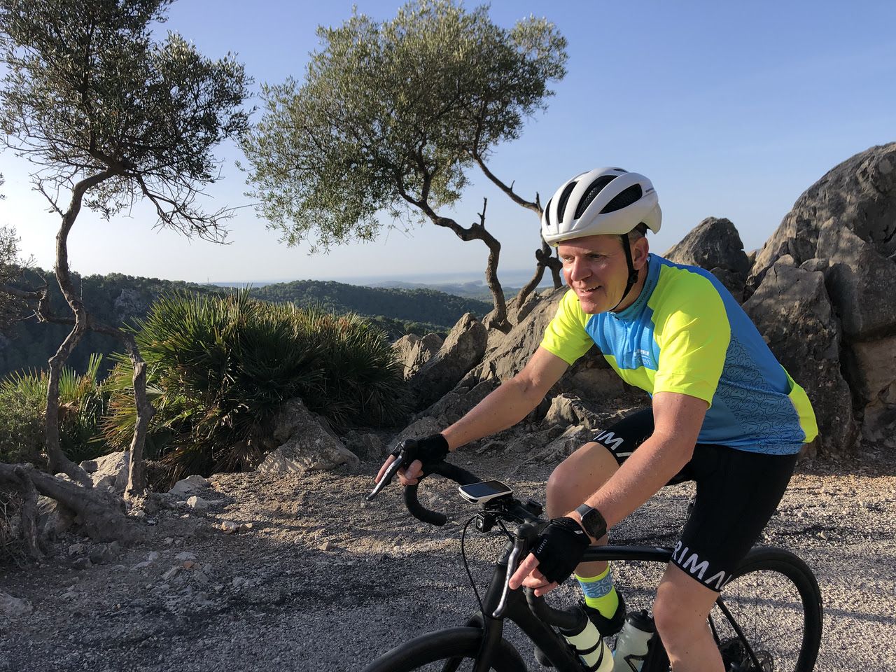 guest riding around a bend with trees behind him