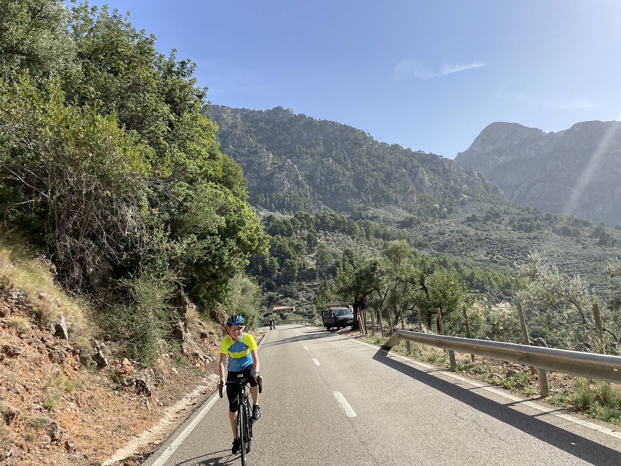 guests riding up a smoothly paved road away from large mountains