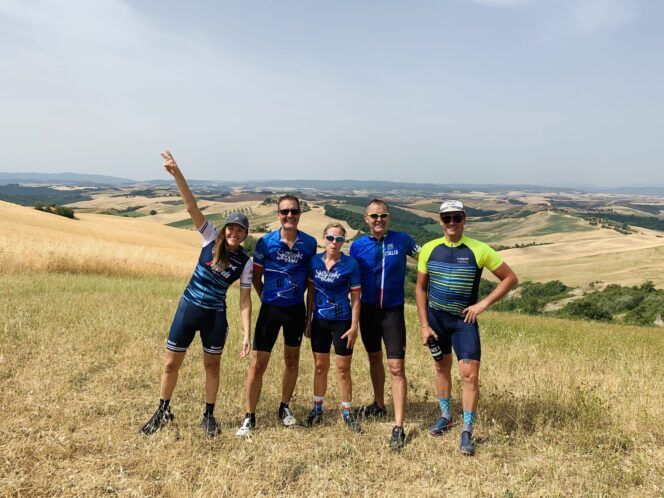 A group of people posing in front of a Tuscany landscape