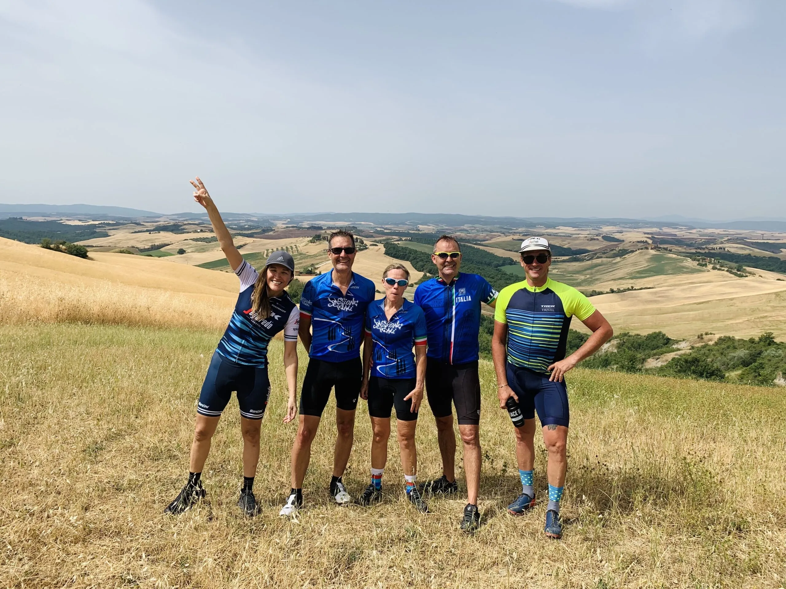 A group of people posing in front of a Tuscany landscape