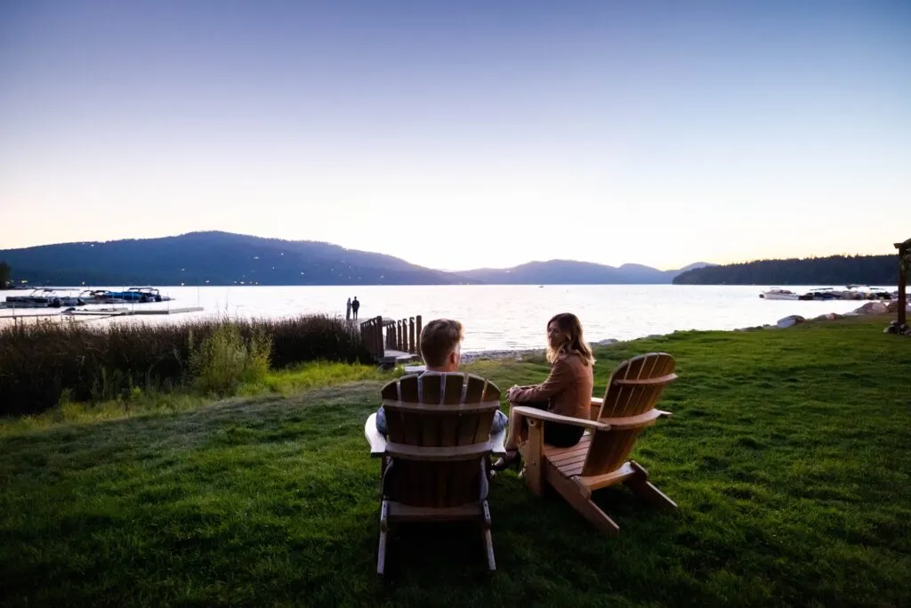 Two people watch the sunset over Whitefish Lake in Glacier