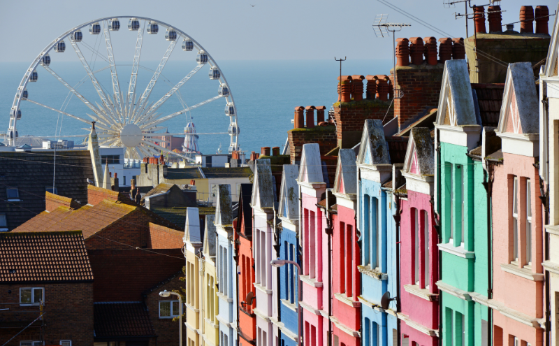 Row of coloured houses in Brighton with big wheel in the background