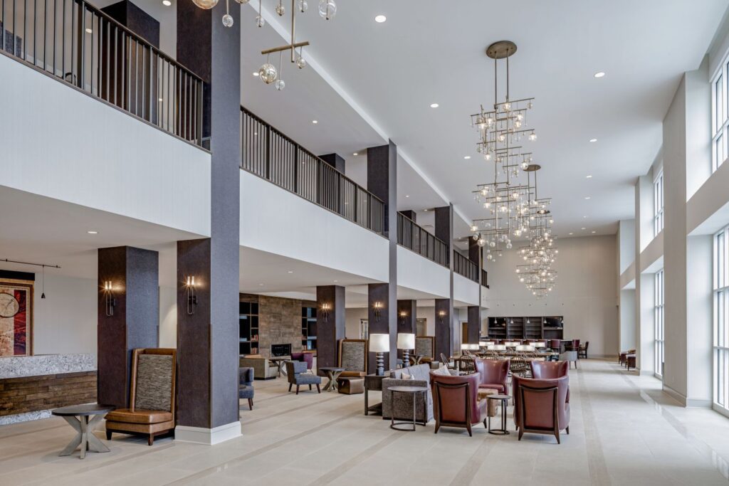 View of spacious lobby of Hotel Madison with chandeliers and furniture