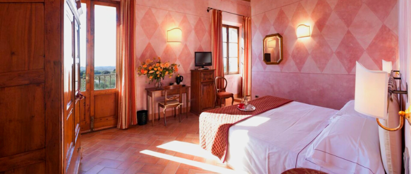 Double hotel room with sun streaming in large windowns. Painted harlequin design walls.