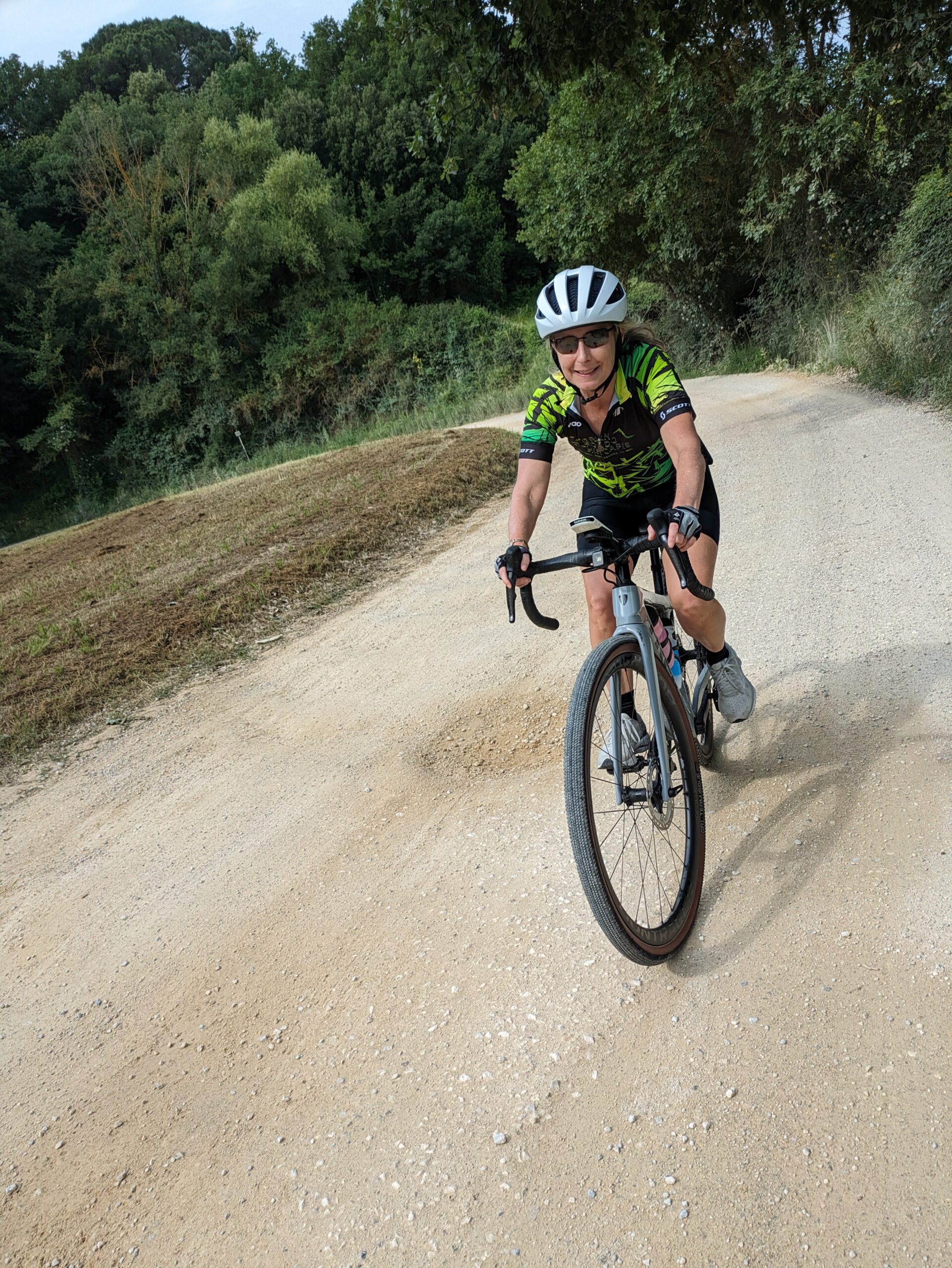 A woman cycling on a gravel road