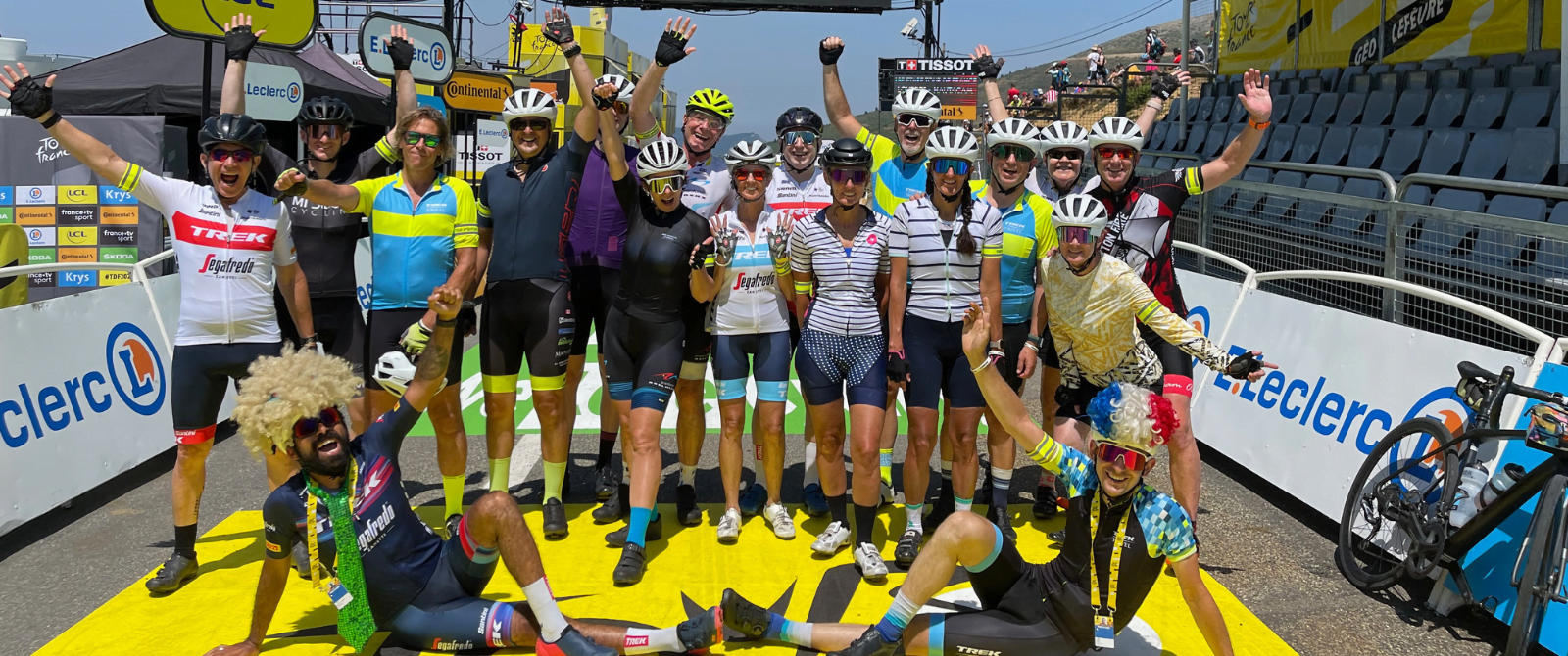 A group of people posing on the finish line of TDF