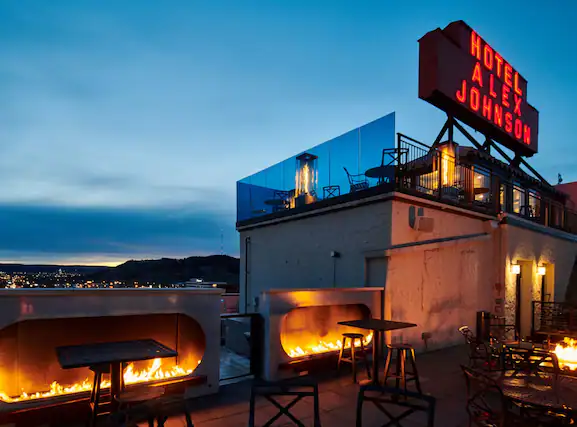 Vertex rooftop patio and bar at dusk with fire pits blazing