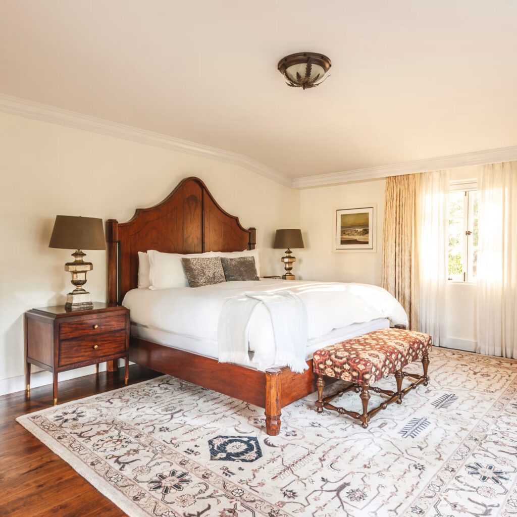 Classic double room with patterned rug and wood headboard at Hotel Belmond El Encanto