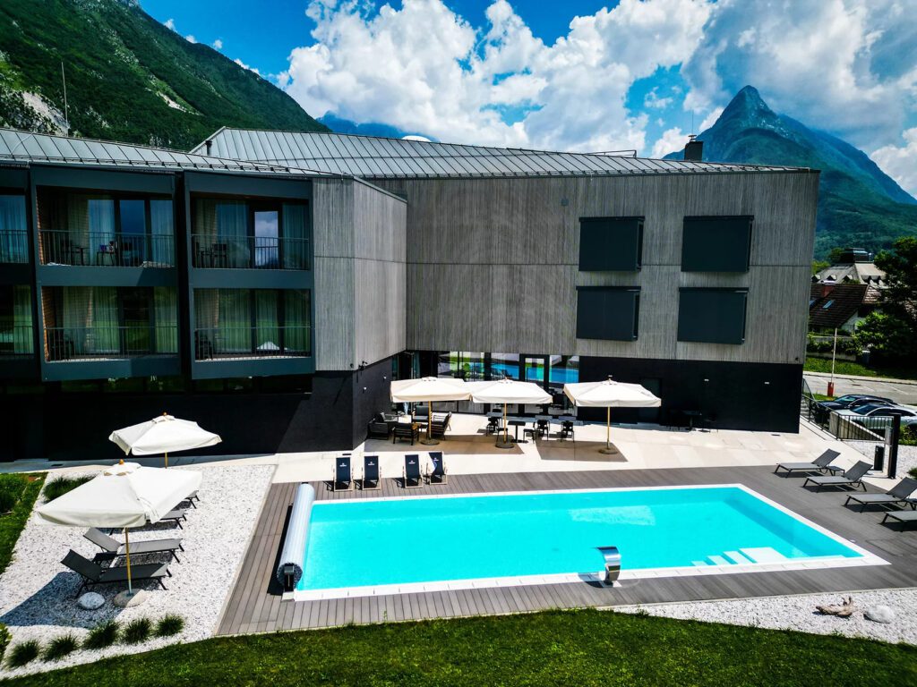 A contemporary grey hotel building with a pool