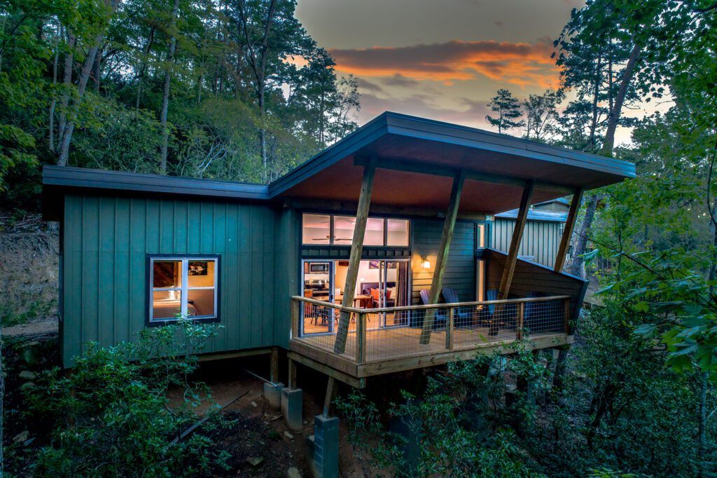 Exterior shot of Pilot Cove cabin, looking onto the deck with sunset in the background