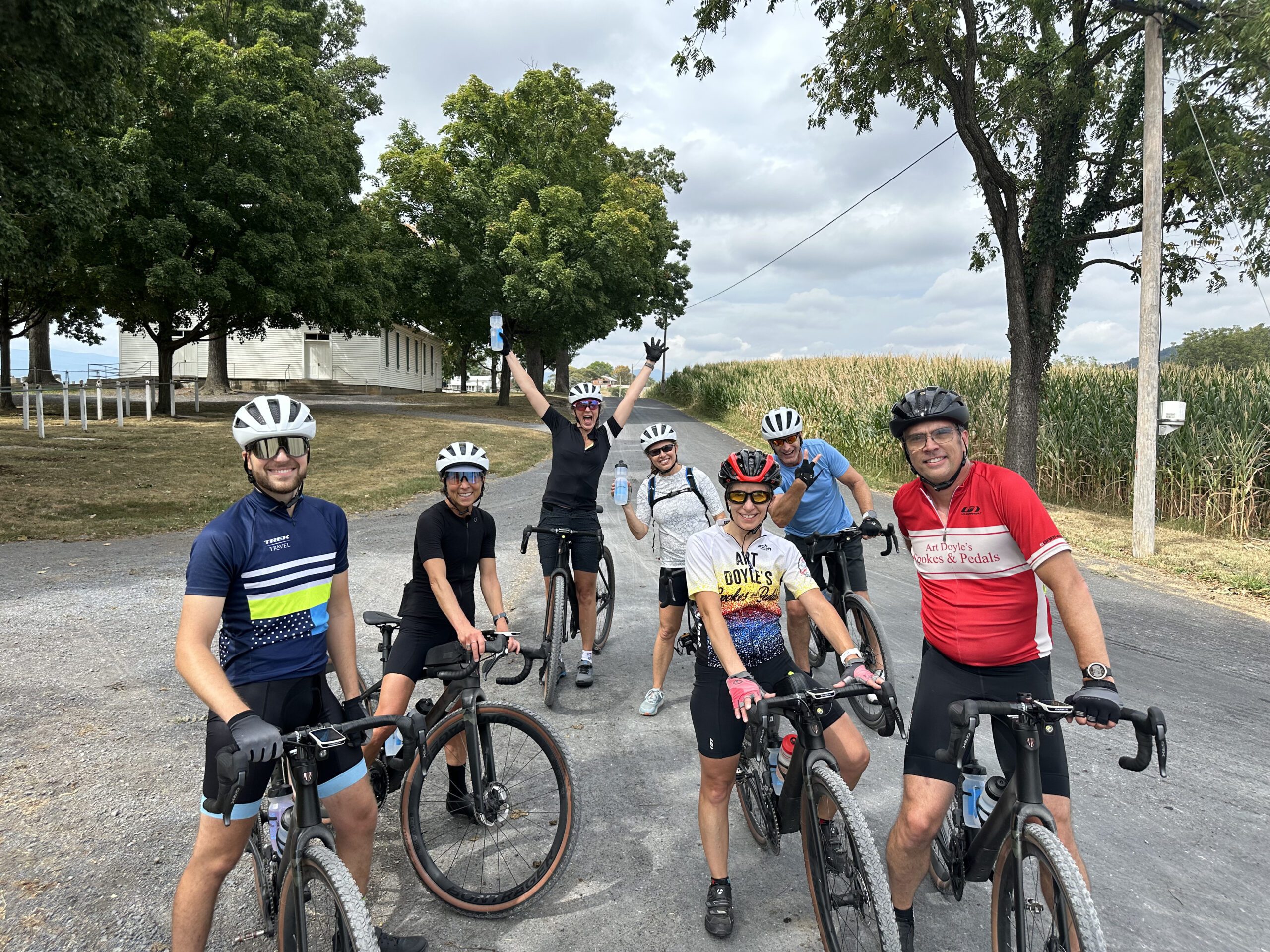 Group of cyclists taking a break on gravel road in front of church