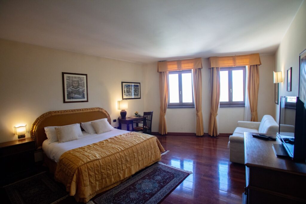 Hotel room with wood floors and gold linens