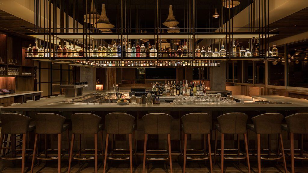 Bar with high chairs, elevated bottle and mood lighting