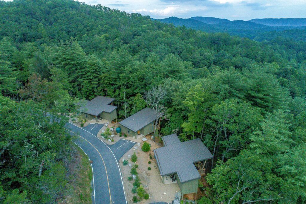 Aerial shot of three cabins at Pilot Cove with mountains in the background