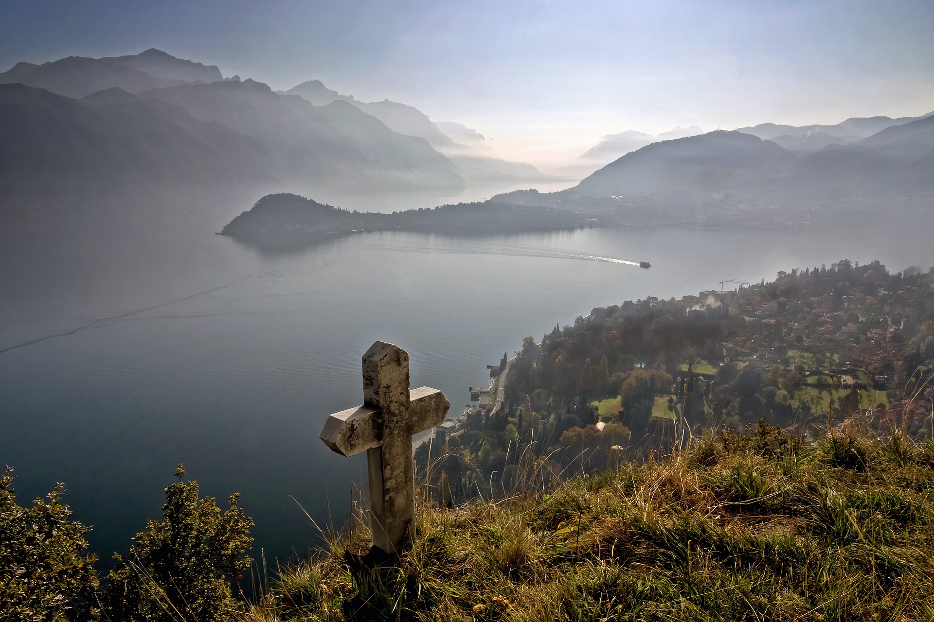 stone cross overlooking lake in italy